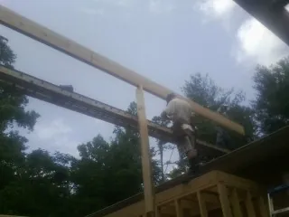 Carpenter setting a ridge beam over a new addition frame — Ice Dam Removal by Roofing Brothers in Sewickley