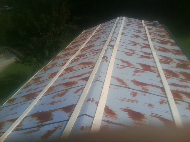 Rusted metal roof panels with new wood purlins before replacement — Storm Damage Roof Repair in Sewickley by Roofing Brothers