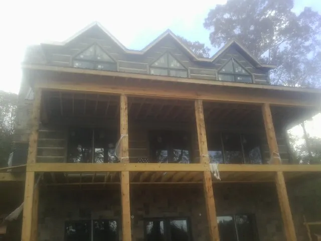 Dormers and porch framing on a large log home under construction — Roof Coating work by our crew in Sewickley