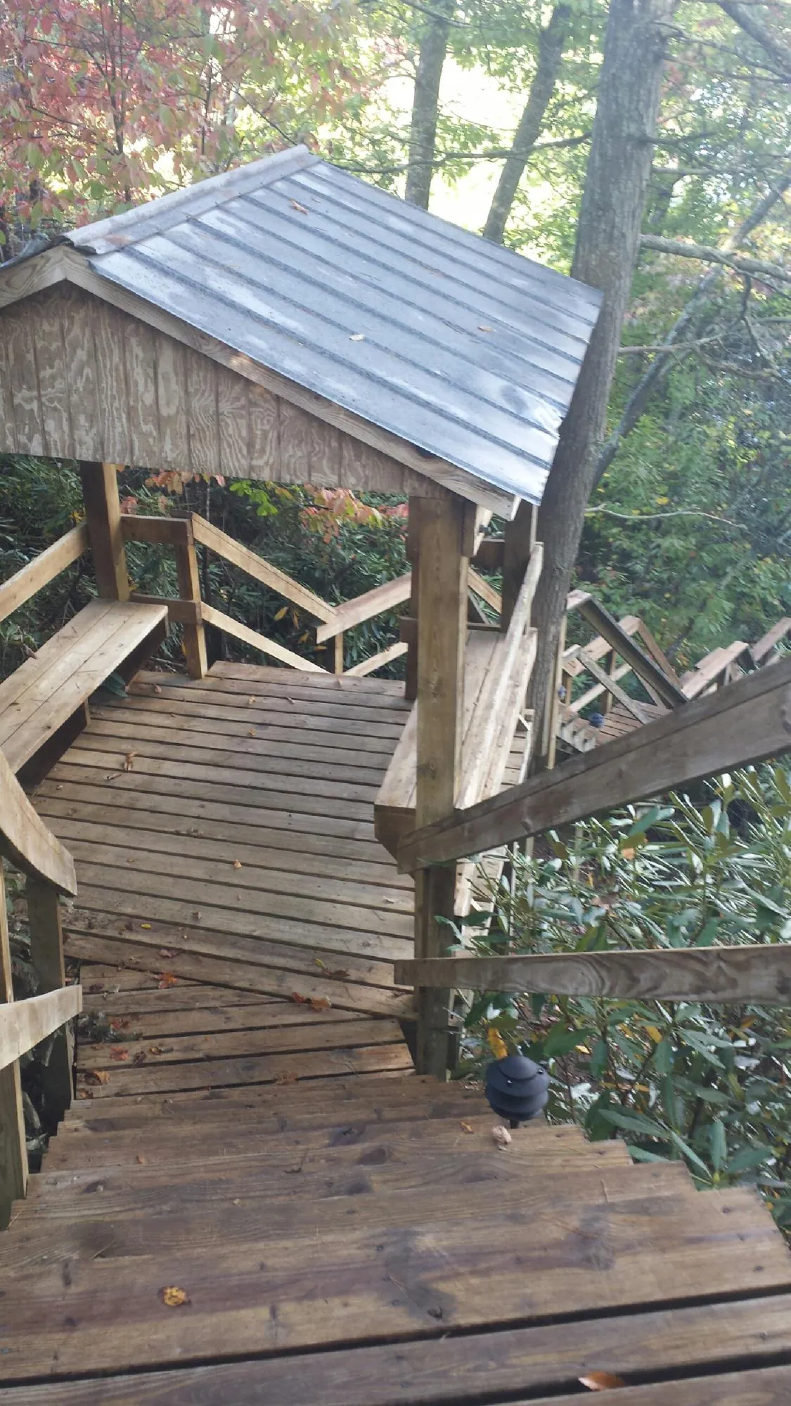 Metal roofed shelter over wooden steps on a wooded walkway — Skylight Repair & Installation work by our crew in Sewickley